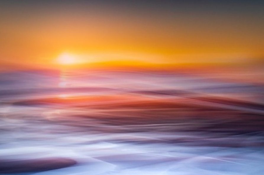 Long Exposure Abstract Ocean Art Orange Sunset Abstract, blurred long-exposure photograph of the ocean at sunset, featuring vivid streaks of orange, red, and electric blue water movement.